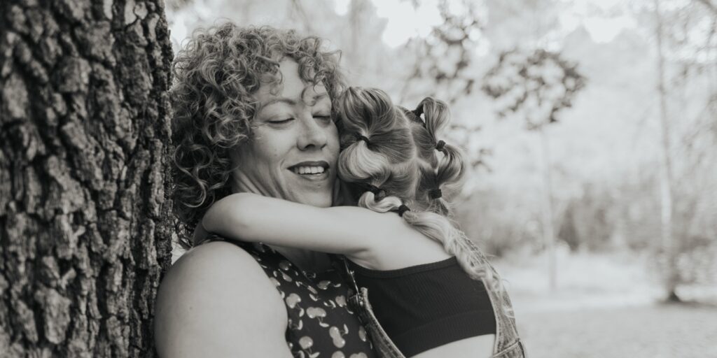 Madre abrazando a su hija durante una sesión de fotos