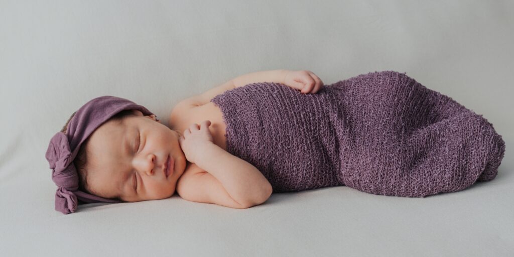 Bebé envuelto en una manta durante una sesión de fotos newborn