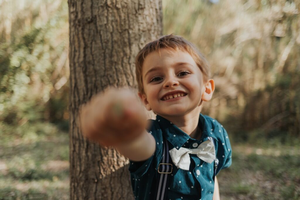 Niño jugando delante de la cámara durante una sesión de fotos en exterior