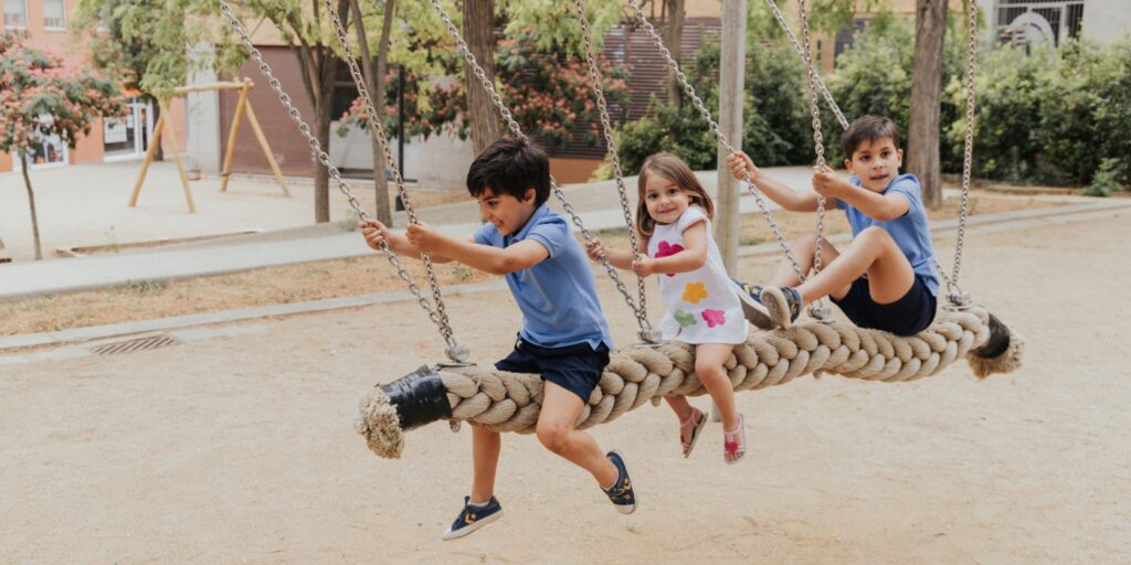 Niños jugando juntos en un columpio